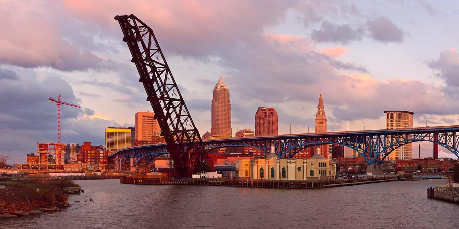 Photo of crane and bridge with a skyline in the background.